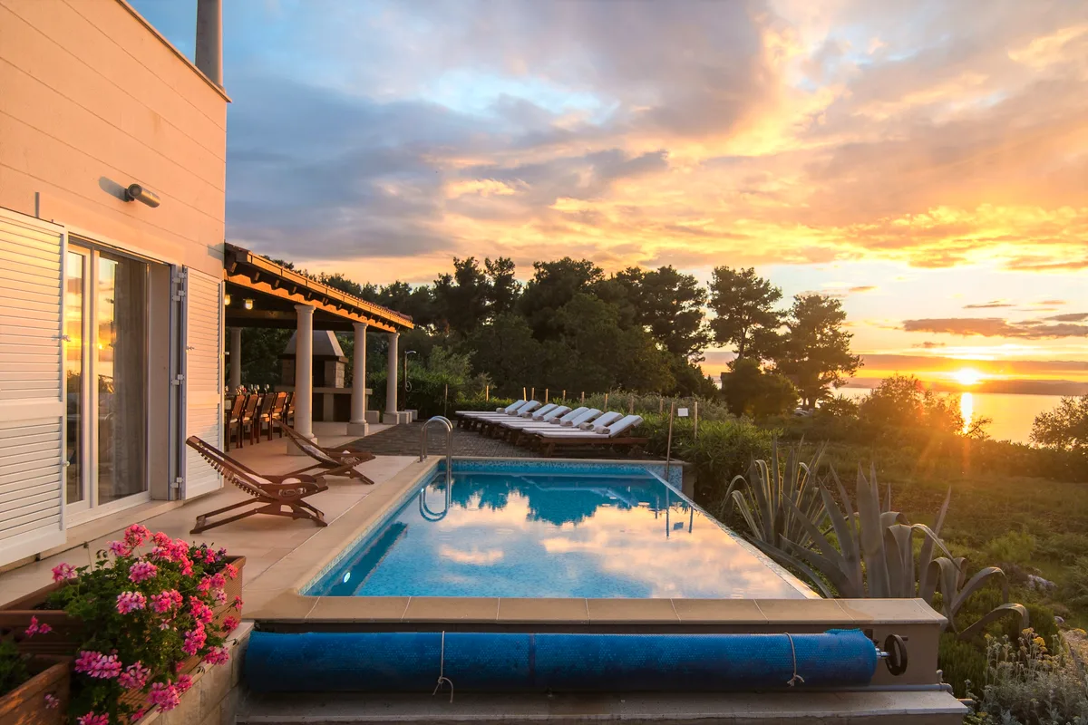 Heated infinity pool at sunset over the Adriatic at Villa Gumonca, retreat venue on Brač Island, Croatia